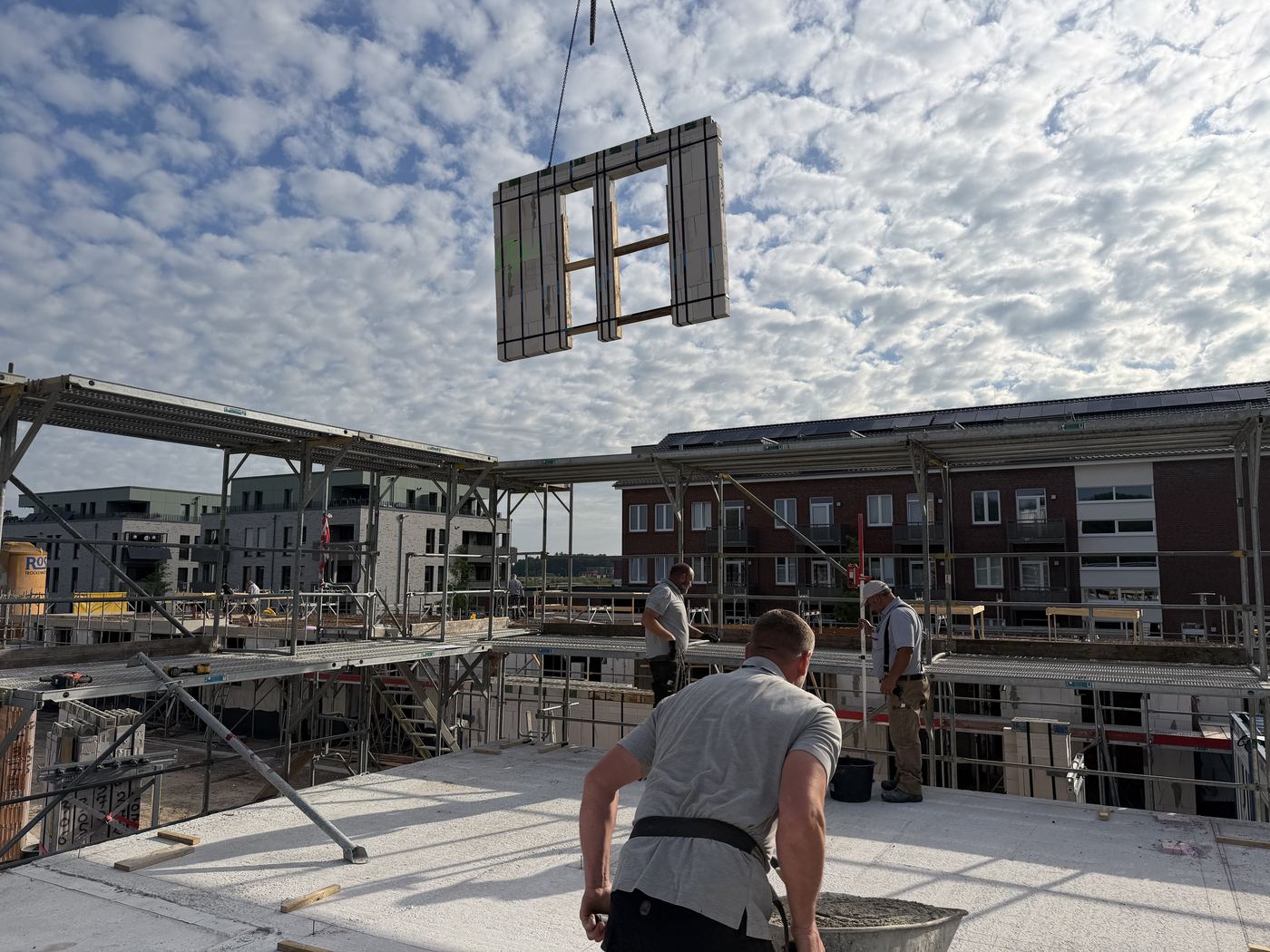 Eine vorgefertigte Mauerwerkstafel mit Fensteröffnung am Kranhaken